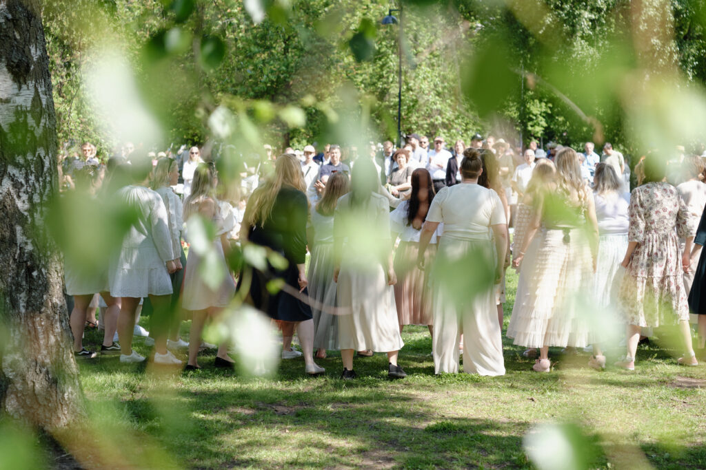 Choir performing in a sunny park.