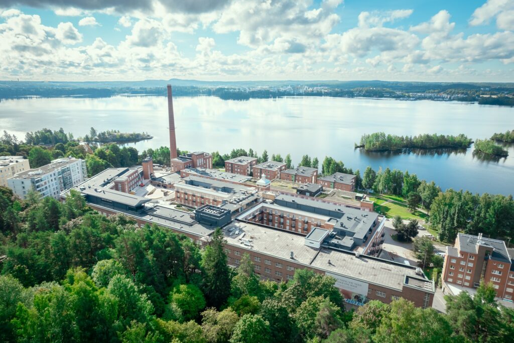 Ilmakuva järven rannalla, vanhassa tiilirakennuksessa sijaitsevasta hotellista.
